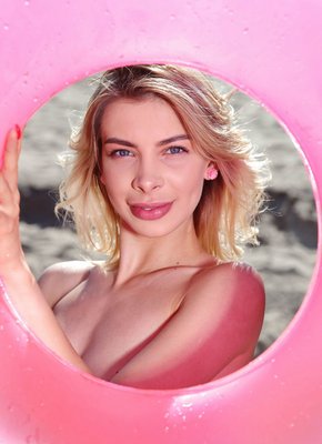 Блондинка с голыми сиськами позирует на пляже