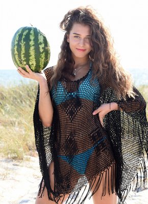 Кудрявая девушка в бикини на пляже