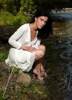 Мокрая брюнетка купается в речке